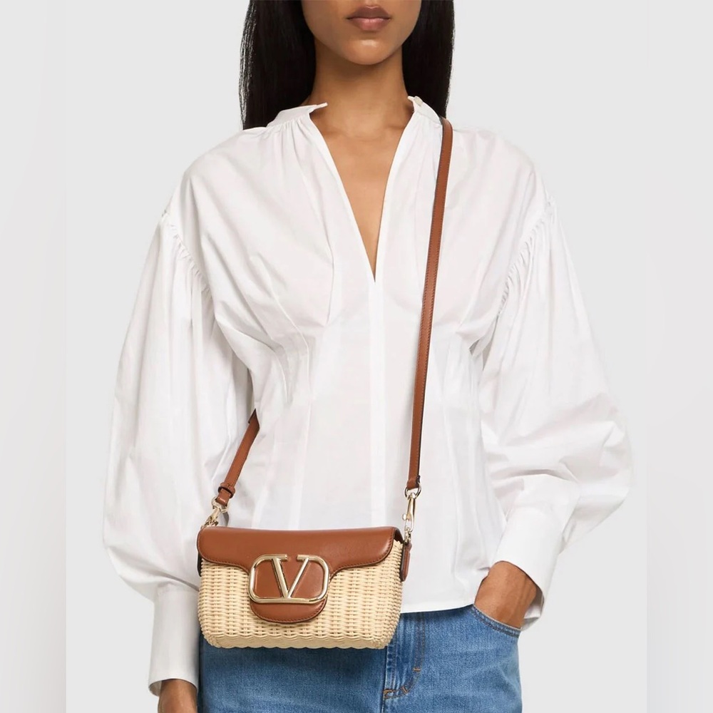 VALENTINO GARAVANI
Logo embellished leather-trimmed raffia shoulder bag